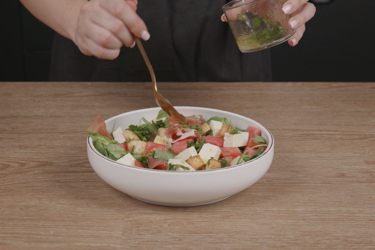 Añadir vinagreta a la ensalada de sandía y queso feta